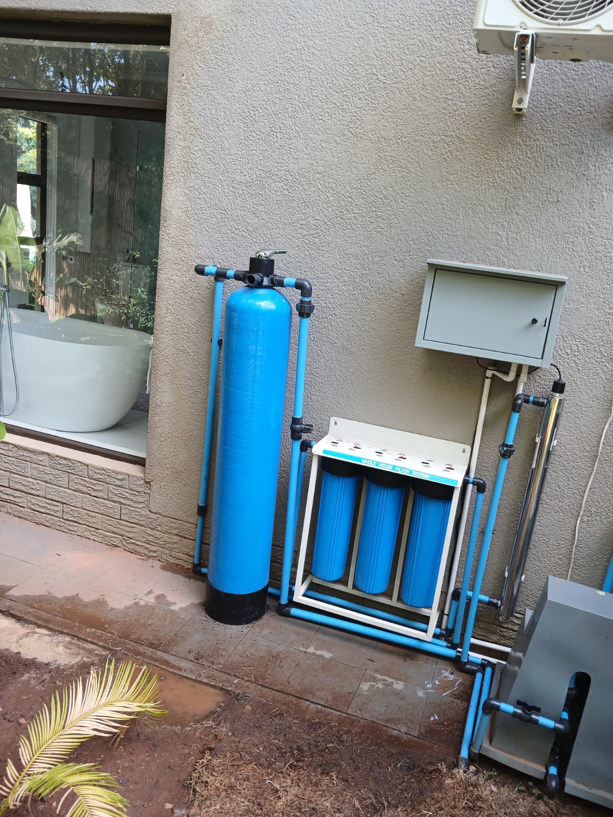 Whole house filter system with blue softener tank and UV steriliser